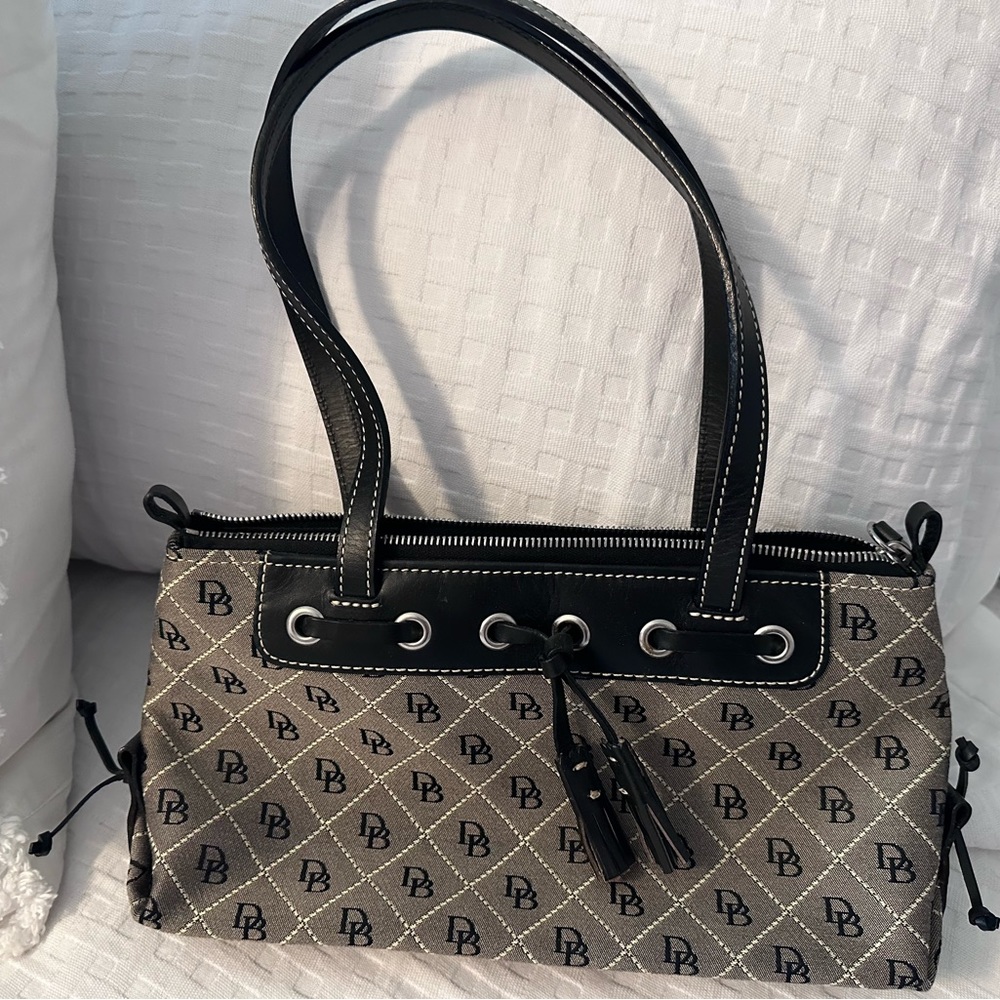 Dooney & Bourke zipper bag with tassels. Never been used.